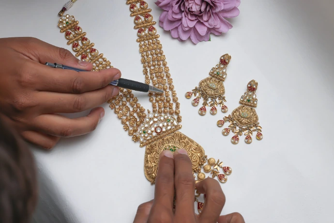 A woman is working on a gold necklace